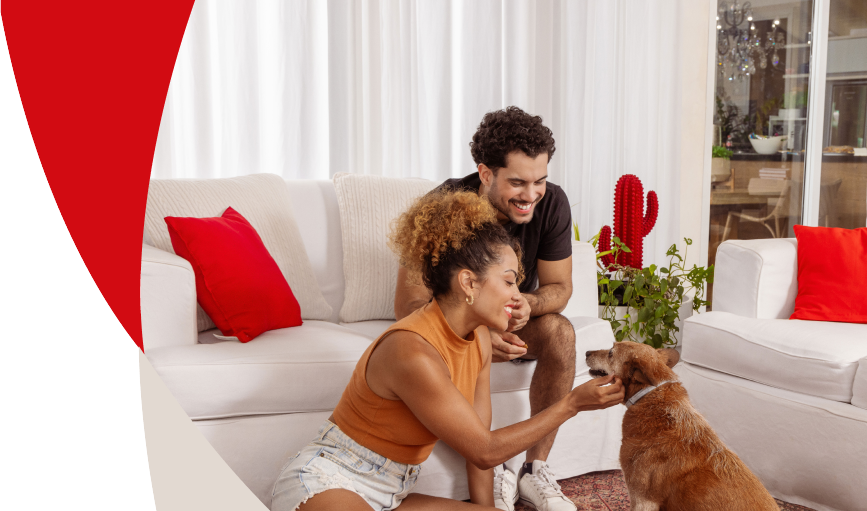 Casal sorrindo olhando para seu cachorro